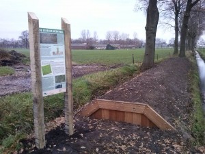 De herstelde meenwal en het onlangs geplaatste informatiebord (foto Uitdetijd)